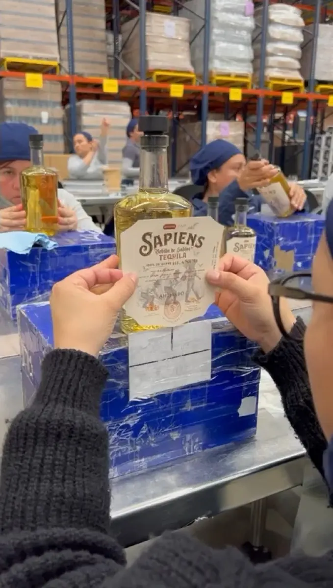 Labelling a bottle of Sapiens Ahumado by hand